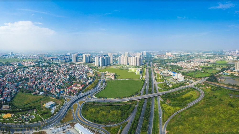 Bình nước thể thao màu trắng và đen đặt trên bàn gỗ với nền cây xanh
